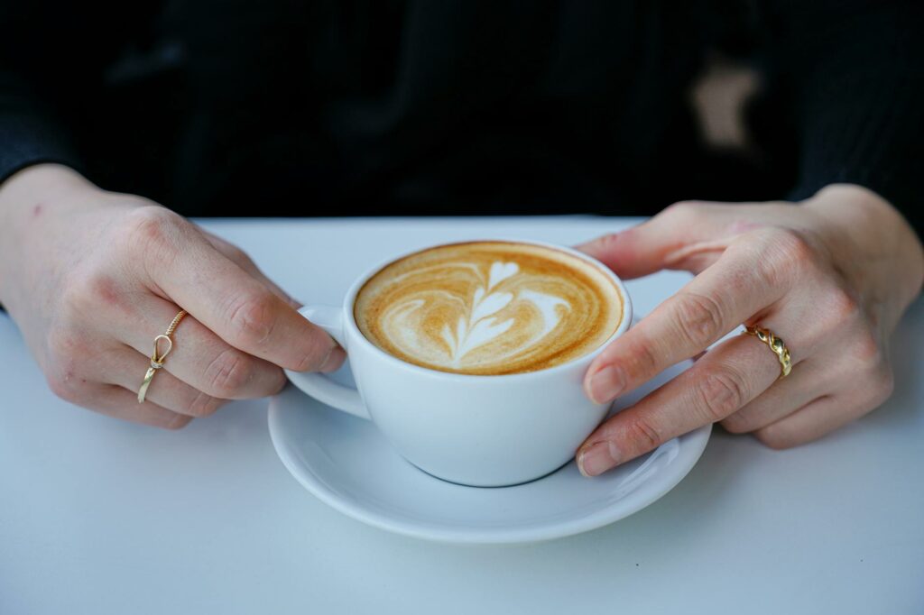 latte art coffee in hands with rings