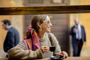Woman drinking espresso coffee at traditional old style italian cafe on a bar at window on cozy street. Concept of italian lifestyle