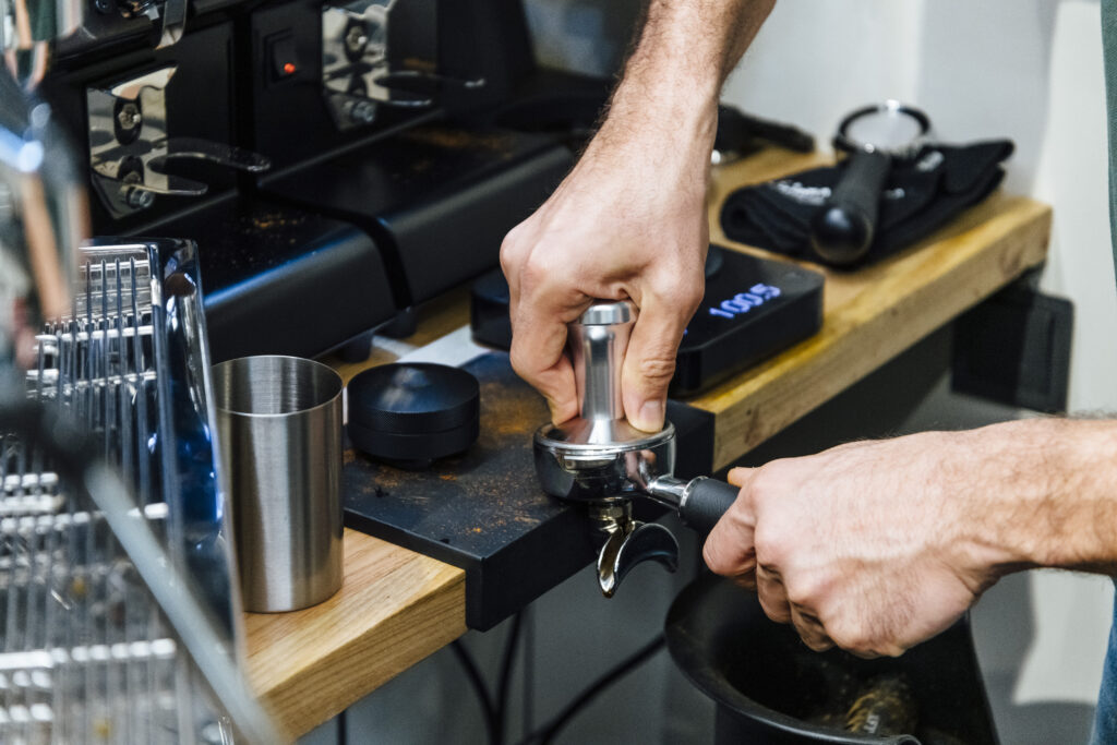 barista pressing coffee to portafilter
